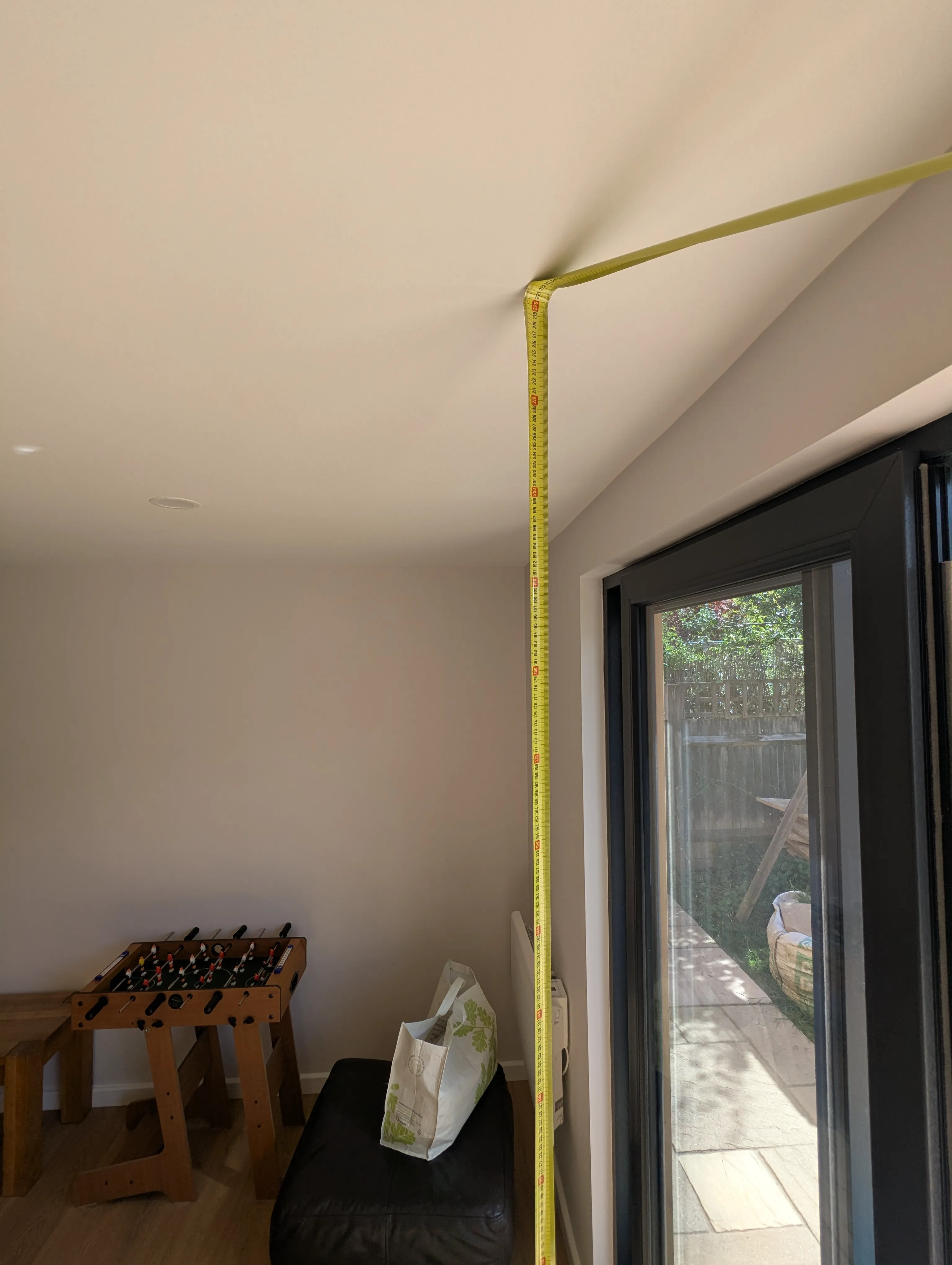 Tape measure run from the finished floor to the ceiling inside the completed room